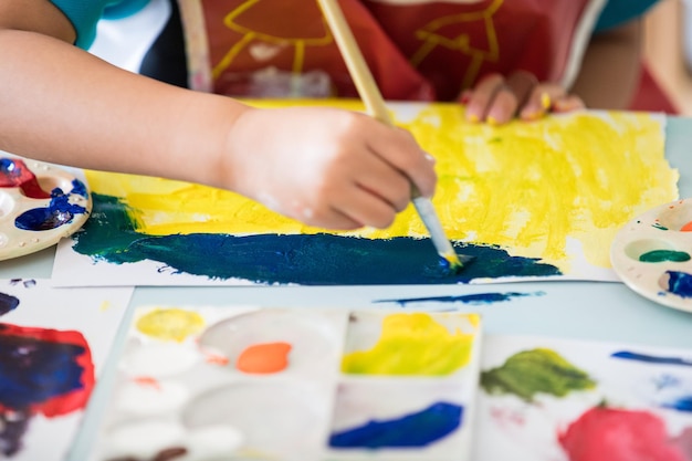 Seção média de pintura de criança sobre papel