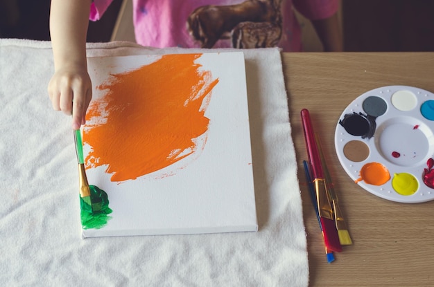 Seção média de pintura de menina na mesa