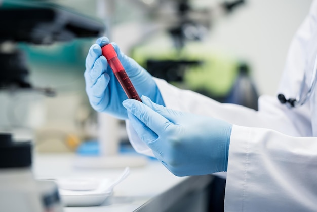 Foto seção média de um cientista segurando um tubo de ensaio em laboratório