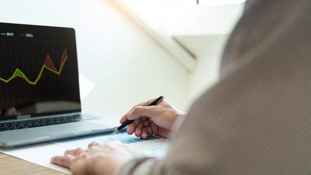 Seção média de um empresário a analisar um relatório na secretária do escritório.