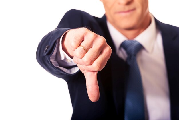 Foto seção média de um empresário fazendo gestos com os polegares para baixo contra um fundo branco
