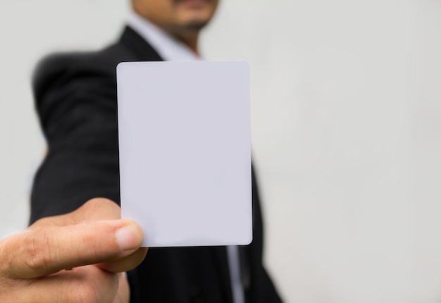 Foto seção média de um empresário segurando um cartaz em branco contra um fundo branco