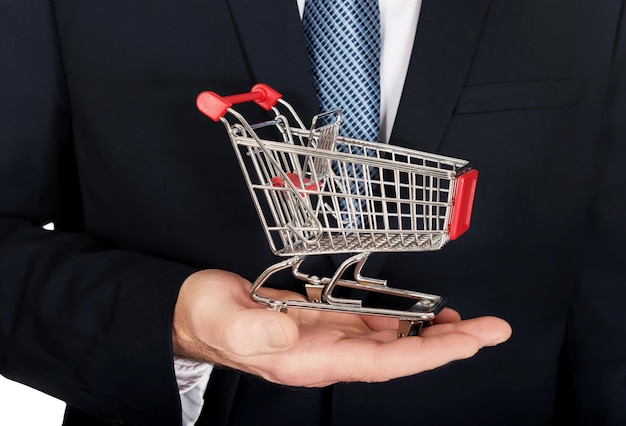 Seção média de um empresário segurando um pequeno carrinho de compras