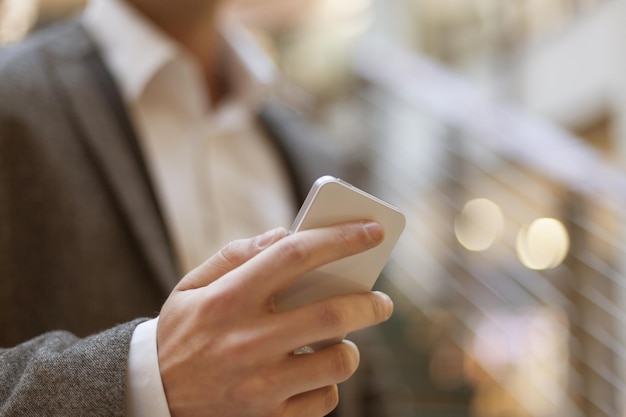 Seção média de um empresário usando o telefone enquanto está de pé ao ar livre