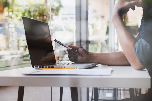 Foto seção média de um homem apontando para um laptop no escritório