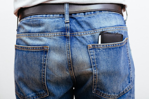 Seção média de um homem com carteira no bolso contra fundo branco