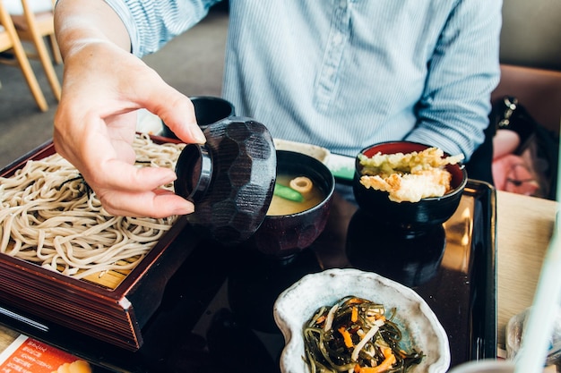 Foto seção média de um homem comendo comida na mesa