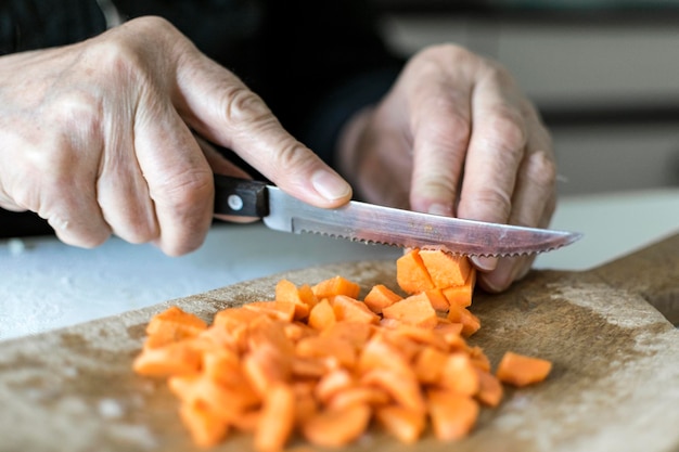 Foto seção média de um homem cortando cenouras na prancha de corte