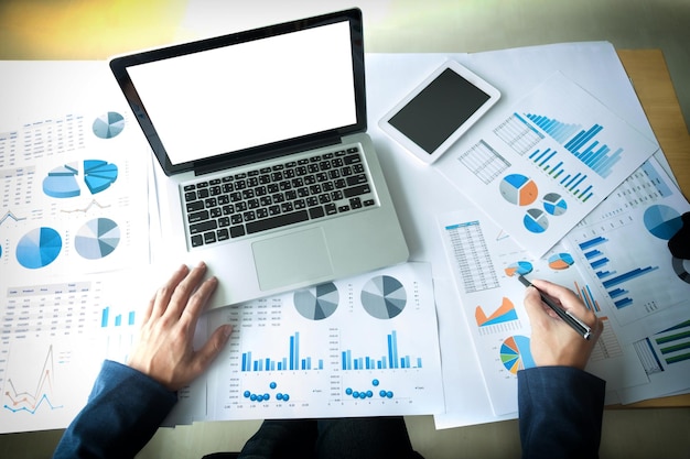 Seção média de um homem de negócios analisando gráficos na mesa