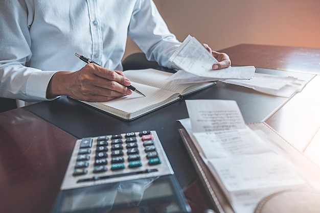 Seção média de um homem de negócios calculando contas na mesa