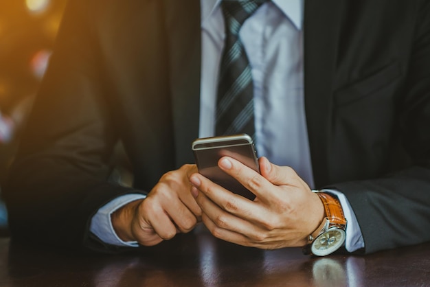 Seção média de um homem de negócios usando o telefone na mesa