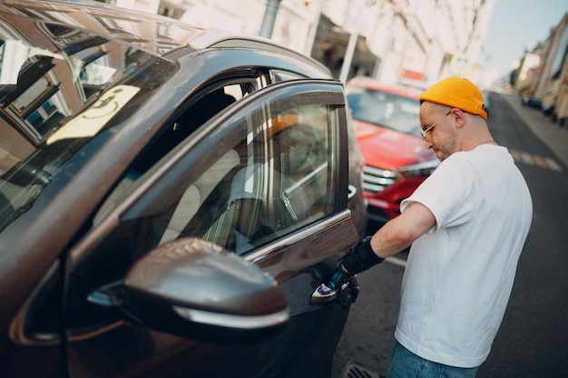 Seção média de um homem de pé ao lado do carro.
