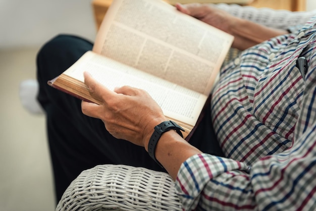 Seção média de um homem lendo um livro enquanto descansa em casa