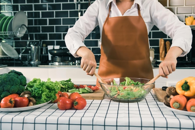 Seção média de um homem preparando comida na cozinha em casa