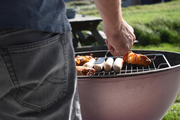 Seção média de um homem preparando comida no churrasco