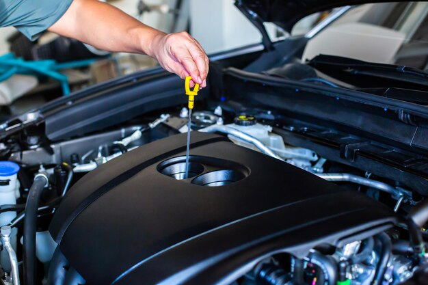 Foto seção média de um homem reparando o motor de um carro