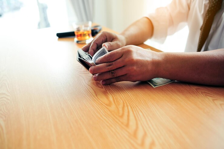 Foto seção média de um homem segurando cartas de jogo na mesa