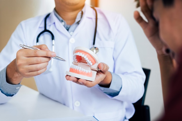 Seção média de um homem segurando dentaduras