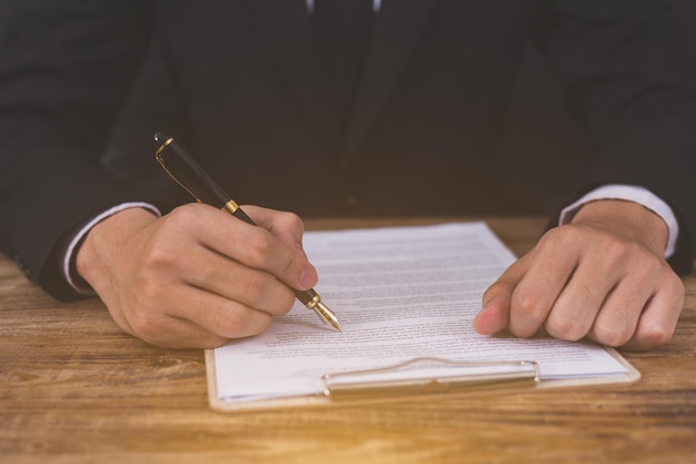 Seção média de um homem segurando papel na mesa