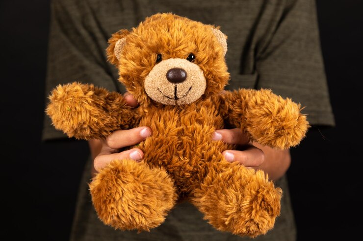 Foto seção média de um homem segurando um brinquedo de pelúcia