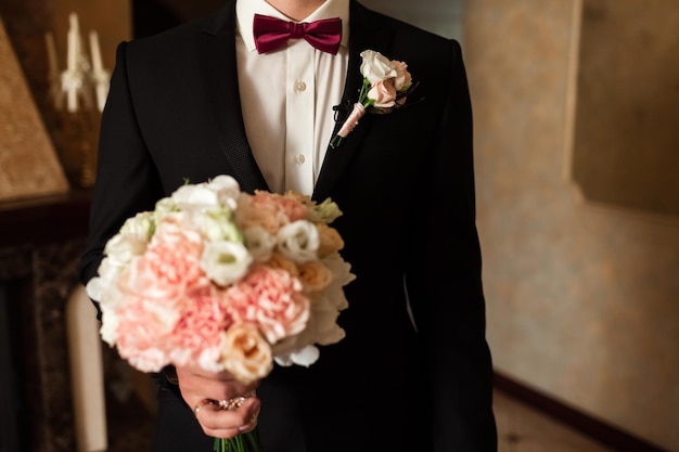 Seção média de um homem segurando um buquê de rosas