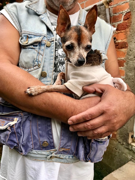 Foto seção média de um homem segurando um cão