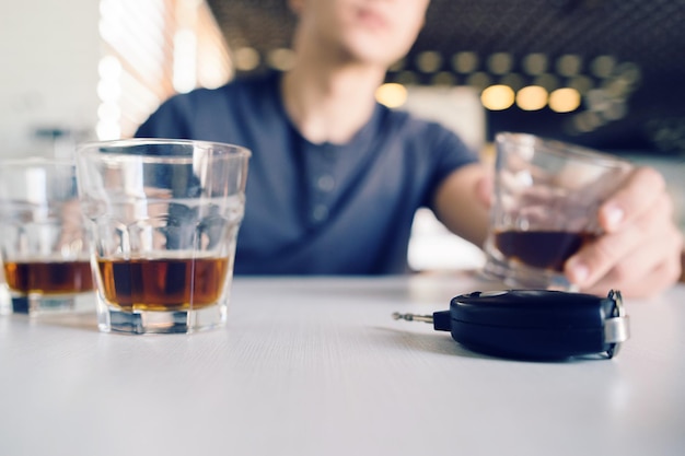 Foto seção média de um homem segurando um copo de cerveja na mesa