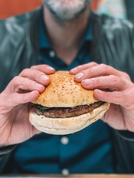 Foto seção média de um homem segurando um hambúrguer