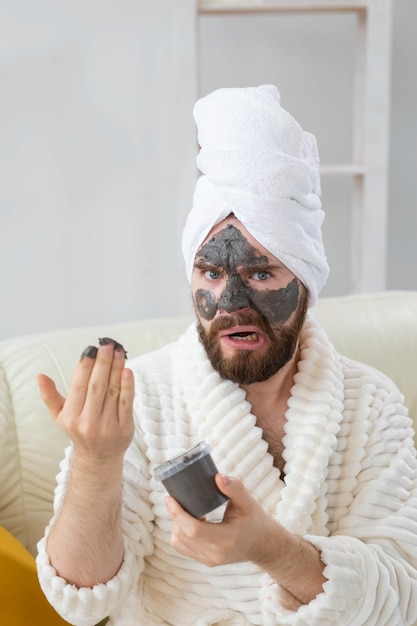 Foto seção média de um homem segurando um telefone celular em casa