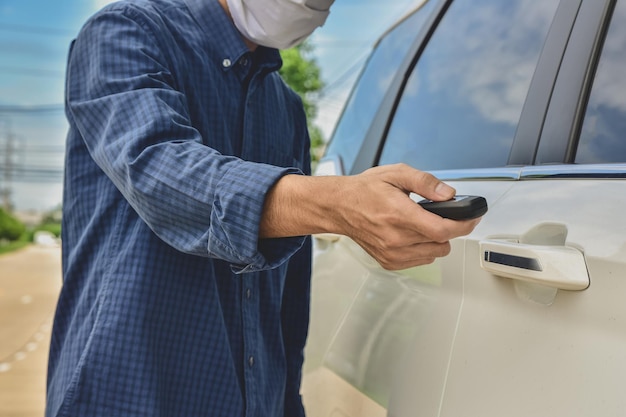 Seção média de um homem segurando um telefone móvel enquanto está de pé no carro