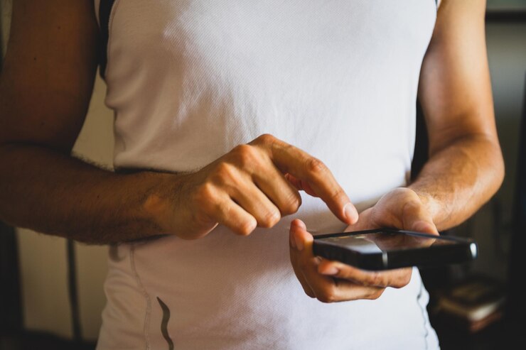 Foto seção média de um homem segurando um telefone móvel