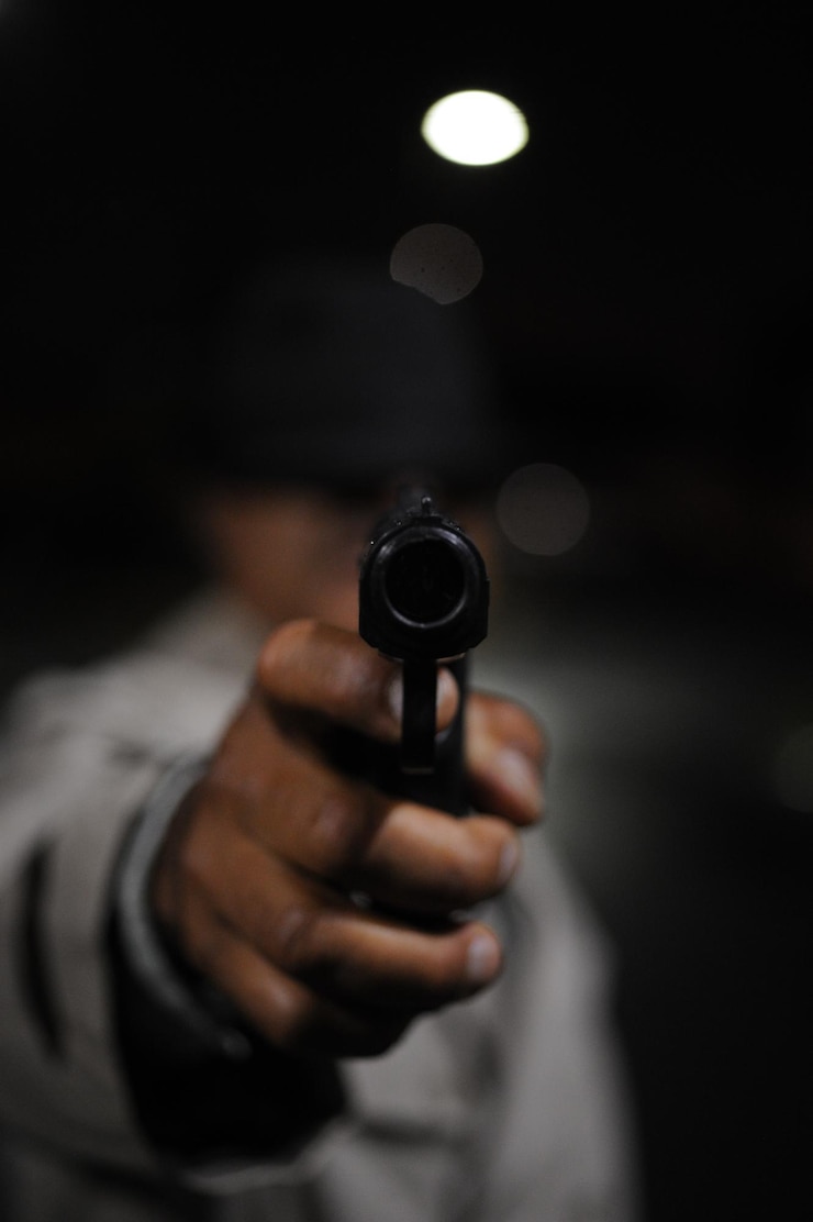 Foto seção média de um homem segurando uma arma
