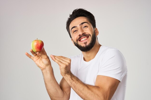 Foto seção média de um homem segurando uma maçã contra um fundo branco