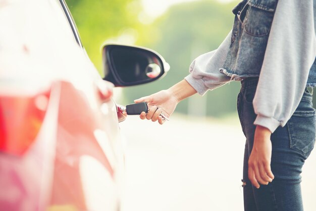 Seção média de um homem segurando uma mulher de pé perto de um carro