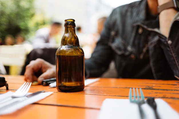 Foto seção média de um homem sentado com uma bebida na mesa