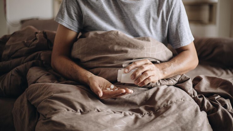 Foto seção média de um homem sentado na cama em casa