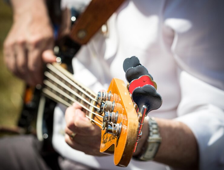 Foto seção média de um homem tocando guitarra ao ar livre