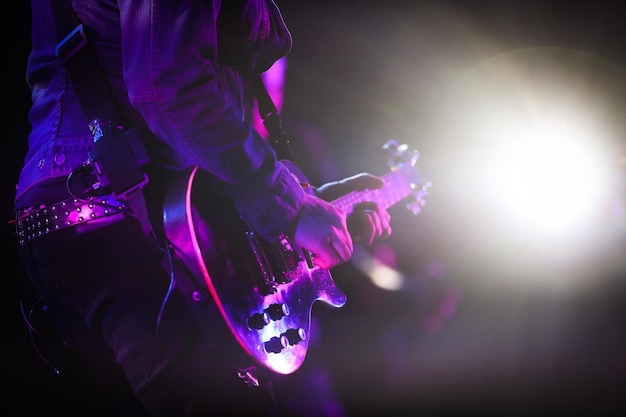 Seção média de um homem tocando guitarra em um concerto de música