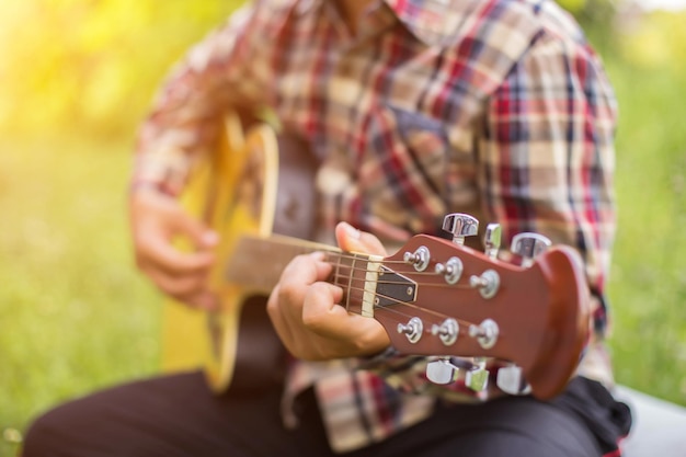Foto seção média de um homem tocando guitarra no parque
