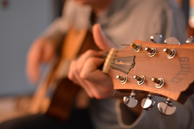 Seção média de um homem tocando guitarra