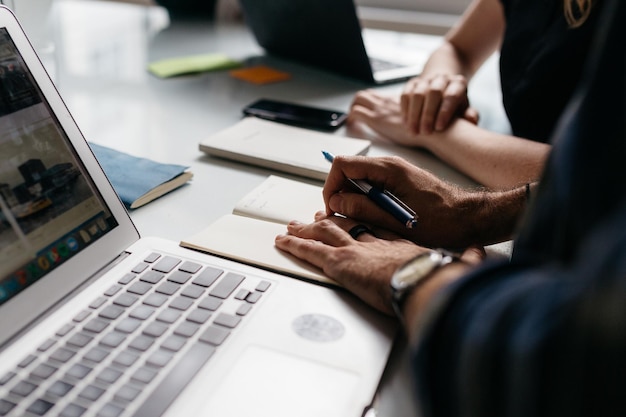 Seção média de um homem usando laptop na mesa
