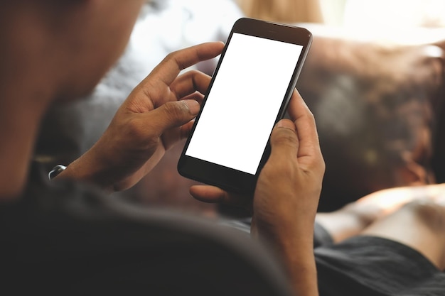 Seção média de um homem usando telefone móvel em casa
