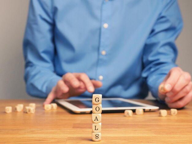 Seção média de um homem usando um tablet digital na mesa por blocos de brinquedos