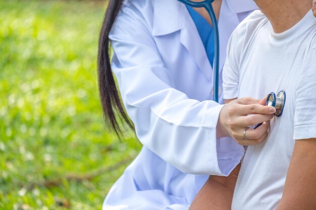 Foto seção média de um médico examinando um paciente com um estetoscópio