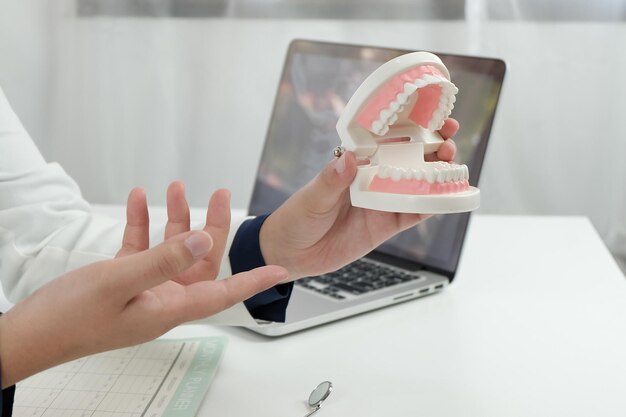 Seção média de um médico segurando equipamentos dentários na mesa