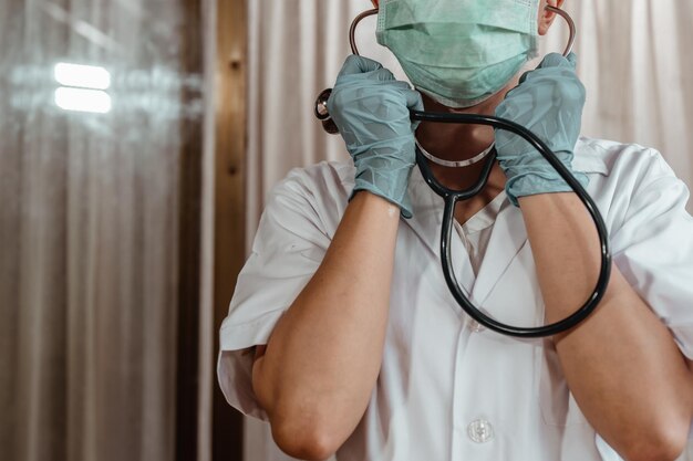 Foto seção média de um médico usando máscara no hospital