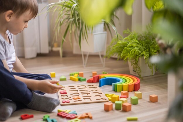 Seção média de um menino brincando com blocos de brinquedo em casa