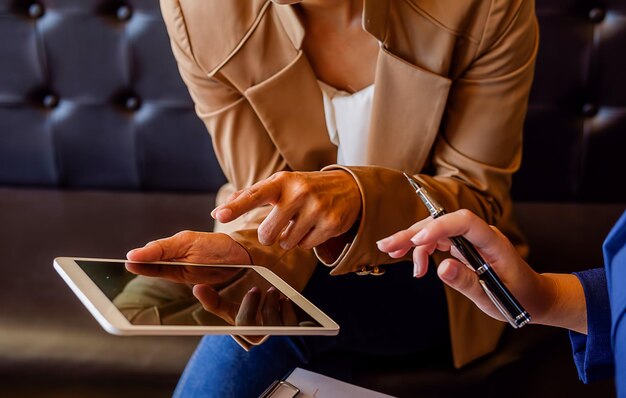 Foto seção média de uma mulher com um colega segurando um tablet digital no escritório