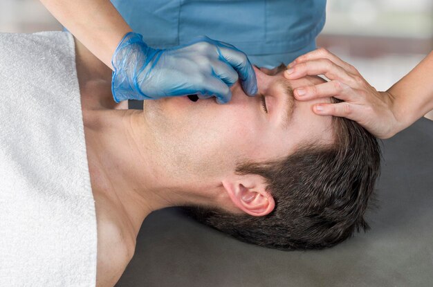 Foto seção média de uma mulher dando massagem a um homem em um spa de beleza