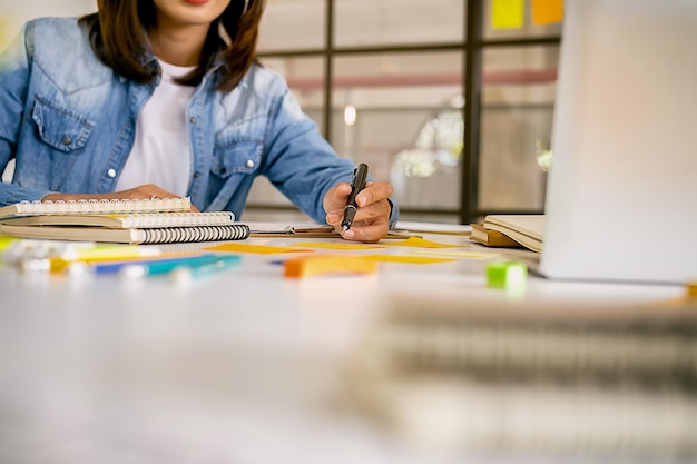 Foto seção média de uma mulher de negócios escrevendo em uma mesa no escritório